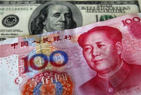A yuan banknote is displayed next to a U.S. dollar banknote for the photographer at a money changer inside the Taoyuan International Airport A yuan banknote is displayed next to a U.S. dollar banknote for the photographer at a money changer inside the Taoyuan International Airport