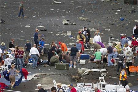 First responders and people rush to help injured spectators following the crash of a vintage World War Two P-51 Mustang fighter plane near t First responders and people rush to help injured spectators following the crash of a vintage World War Two P-51 Mustang fighter plane near t