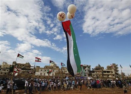 A Palestinian flag attached to balloons flies during a rally in support of Palestinian President Abbas' bid for statehood recognition in the A Palestinian flag attached to balloons flies during a rally in support of Palestinian President Abbas' bid for statehood recognition in the