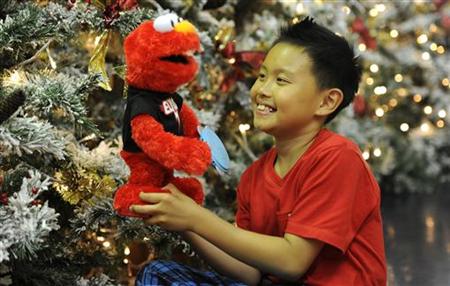 Rio Nguyen, 8, poses for photographers at Hamleys toy store with a Sesame Street Elmo doll in London Rio Nguyen, 8, poses for photographers at Hamleys toy store with a Sesame Street Elmo doll in London
