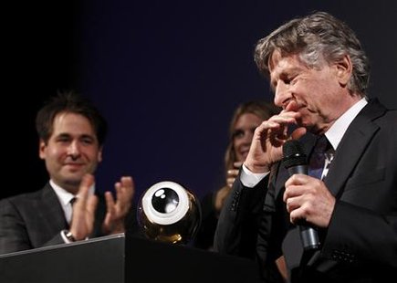 Director Polanski reacts next to Festival Directors Spoerri and Schildknecht after receiving his lifetime achievement award at the Zurich Fi Director Polanski reacts next to Festival Directors Spoerri and Schildknecht after receiving his lifetime achievement award at the Zurich Fi