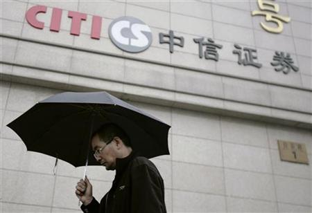 A man walks by the logo of CITIC Securities at a branch of the security brokerage house in Beijing A man walks by the logo of CITIC Securities at a branch of the security brokerage house in Beijing