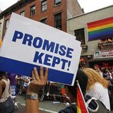 A participant in the Gay Pride Parade holds a sign reading, 'Promise Kept!' in reference to the recent legalization of gay marriage as they 