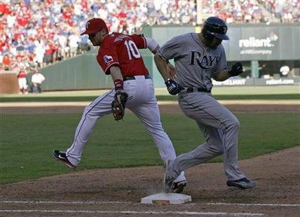 Rangers' Young gets the throw too late on a throwing error by third baseman Beltre to tag Rays Damon at first base in Arlington Rangers' Young gets the throw too late on a throwing error by third baseman Beltre to tag Rays Damon at first base in Arlington