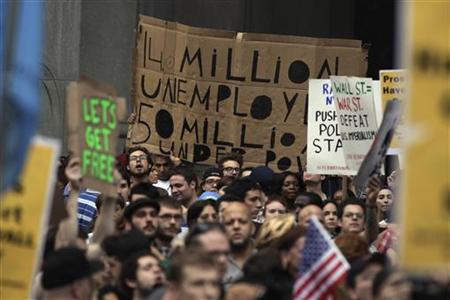 Demonstrators from the Occupy Wall Street campaign hold signs aloft as a protest march enters the courtyard near the New York Police Departm Demonstrators from the Occupy Wall Street campaign hold signs aloft as a protest march enters the courtyard near the New York Police Departm