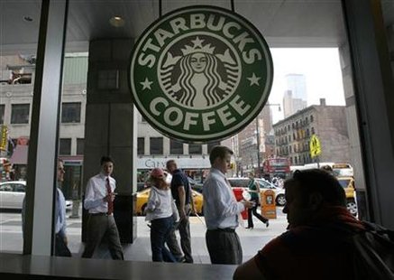Poeple walk past the Starbucks outlet on 47th and 8th Avenue in New York Poeple walk past the Starbucks outlet on 47th and 8th Avenue in New York