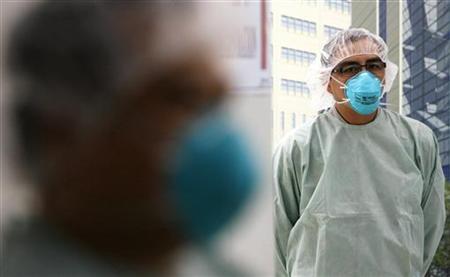 Medical staff wearing protective masks stand in an assessment area for patients with symptoms of respiratory illnesses at a hospital in Sing Medical staff wearing protective masks stand in an assessment area for patients with symptoms of respiratory illnesses at a hospital in Sing