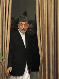 Afghanistan's President Hamid Karzai and India's Prime Minister Manmohan Singh arrive for signing of a joint statement at Hyderabad House in Afghanistan's President Hamid Karzai and India's Prime Minister Manmohan Singh arrive for signing of a joint statement at Hyderabad House in