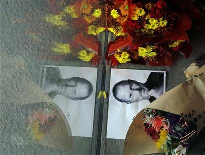 Flowers and a photograph of Steve Jobs are placed against the window outside an Apple store in Boston Flowers and a photograph of Steve Jobs are placed against the window outside an Apple store in Boston