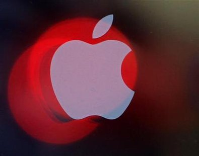 Ambulance lights are reflected on a glass window with a logo of Apple Inc in Tokyo