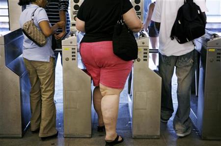 Subway commuters walk through the turnstiles while leaving the U.S. Open in New York Subway commuters walk through the turnstiles while leaving the U.S. Open in New York