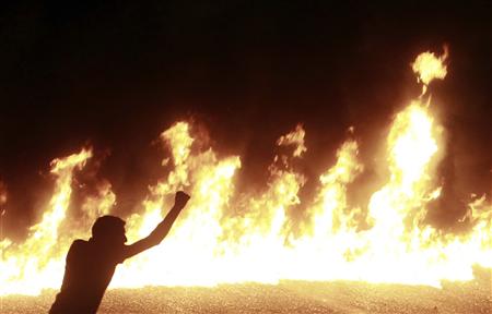 A protester stands near a line of fire during a demonstration in Cairo A protester stands near a line of fire during a demonstration in Cairo