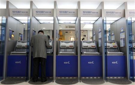 A customer uses an automated teller machine at the headquarters of the Korea Exchange Bank in Seoul A customer uses an automated teller machine at the headquarters of the Korea Exchange Bank in Seoul