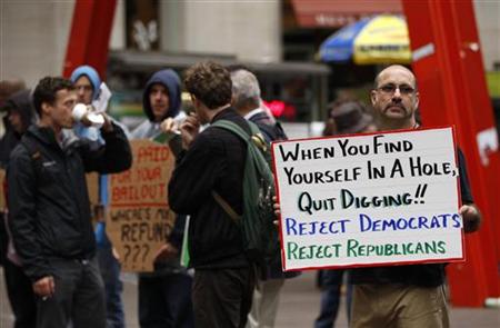 A member of the Occupy Wall St movement holds a sign as he demonstrates in Zuccotti Park near the financial district of New York
