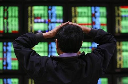 A man looks at stock market prices on computer monitors inside a securities company in Taipei A man looks at stock market prices on computer monitors inside a securities company in Taipei