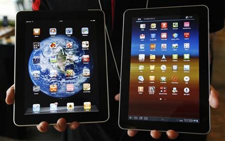 An employee of South Korean mobile carrier KT holds a Samsung Electronics' Galaxy Tab 10.1 tablet and Apple Inc's iPad tablet as he poses in An employee of South Korean mobile carrier KT holds a Samsung Electronics' Galaxy Tab 10.1 tablet and Apple Inc's iPad tablet as he poses in