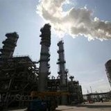 Smoke rises from a refinery