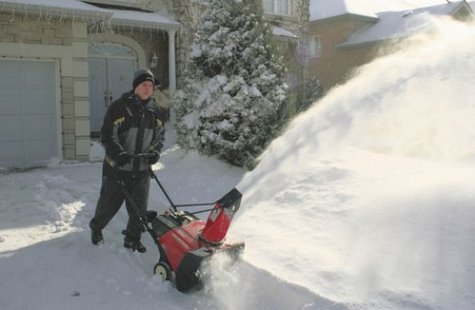 Man operating a snowblower. Man operating a snowblower.