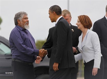 President Obama greets Aboriginal leader Risk as Australian PM Gillard watches upon arriving in Darwin