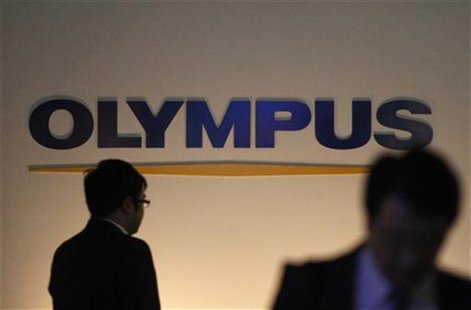 Passersby walk past the company logo of Olympus Corp. in Tokyo Passersby walk past the company logo of Olympus Corp. in Tokyo