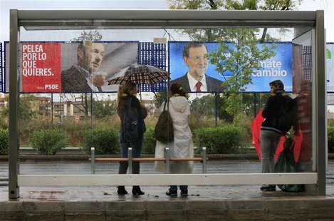 People wait in front of electoral posters at a bus stop in Seville People wait in front of electoral posters at a bus stop in Seville