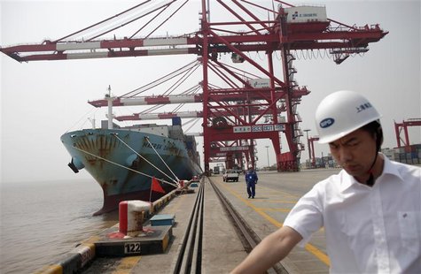 Security personnel work next to a ship docked at a container area at the Yangshan Deep Water Port, south of Shanghai Security personnel work next to a ship docked at a container area at the Yangshan Deep Water Port, south of Shanghai