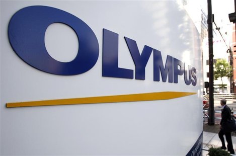 A man walks past a sign of Olympus Corp outside the company's showroom in Tokyo A man walks past a sign of Olympus Corp outside the company's showroom in Tokyo