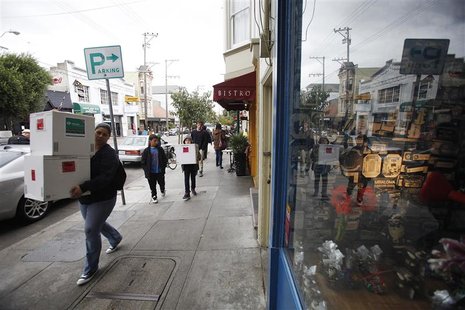 People carrying boxes walk past Chocolate Covered candy shop in the Noe Valley district in San Francisco People carrying boxes walk past Chocolate Covered candy shop in the Noe Valley district in San Francisco