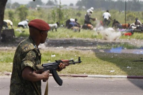 Bullets fired by a member of the presidential guard kick up dust in front of a crowd of opposition supporters in Kinshasa Bullets fired by a member of the presidential guard kick up dust in front of a crowd of opposition supporters in Kinshasa