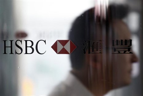 A man walks past the HSBC logo at the bank's headquarters in Hong Kong