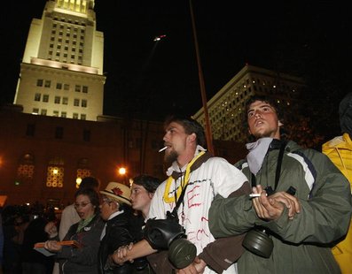 Protesters from the Occupy LA stand with their gas masks as they wait for police at their encampment outside the City Hall in Los Angeles.
