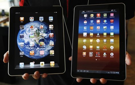 An employee of South Korean mobile carrier KT holds a Samsung Electronics' Galaxy Tab 10.1 tablet and Apple Inc's iPad tablet as he poses in An employee of South Korean mobile carrier KT holds a Samsung Electronics' Galaxy Tab 10.1 tablet and Apple Inc's iPad tablet as he poses in