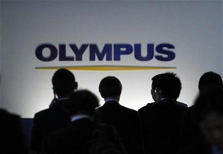 People walk past a sign of Olympus Corp outside the company's showroom in Tokyo People walk past a sign of Olympus Corp outside the company's showroom in Tokyo
