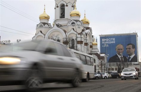 Cars drive past a campaign poster for United Russia in the center of the Russian city of Yekaterinburg Cars drive past a campaign poster for United Russia in the center of the Russian city of Yekaterinburg