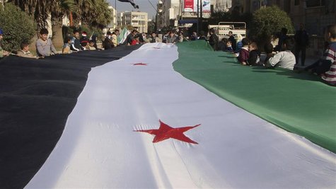 Demonstrators protesting against Syria's President Bashar al-Assad display a 1961-63 Syrian flag during a march through the streets in Adlb
