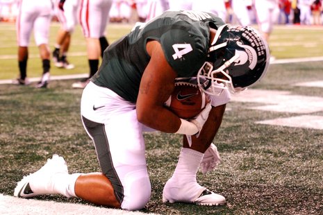 Michigan State Running Back Edwin Baker kneels after scoring a touchdown in the Spartans 42-39 loss to the Wisconsin Badgers in the Big Ten Championship. Michigan State Running Back Edwin Baker kneels after scoring a touchdown in the Spartans 42-39 loss to the Wisconsin Badgers in the Big Ten Championship.