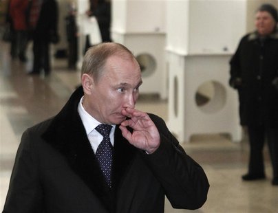 Russia's PM Putin looks on after casting his ballot at a polling station during the parliamentary election in Moscow