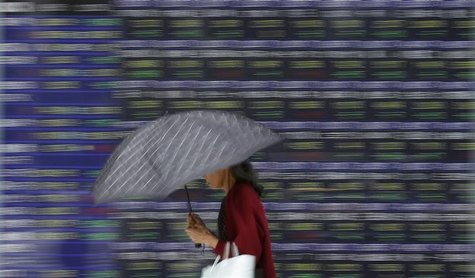 A woman walks past a stock quotation board outside a brokerage in Tokyo A woman walks past a stock quotation board outside a brokerage in Tokyo