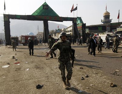 An Afghan National Army soldier disperses the crowd after a suicide attack at a Shi'ite Muslim gathering in Kabul.