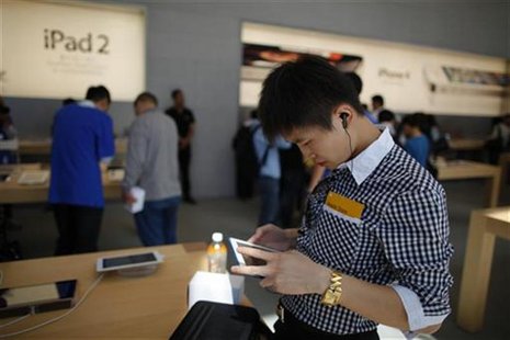 A man looks at an Apple iPad 2 at the company's new store in Nanjing Road, Shanghai A man looks at an Apple iPad 2 at the company's new store in Nanjing Road, Shanghai