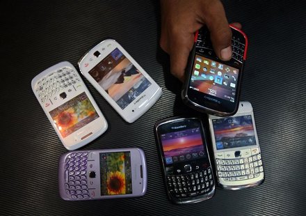 A salesman displays a Blackberry mobile phone to customers next to dummy handsets at a shop in Jammu A salesman displays a Blackberry mobile phone to customers next to dummy handsets at a shop in Jammu