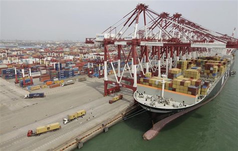 Trucks unload shipping containers from a cargo ship at Qingdao port in Qingdao Trucks unload shipping containers from a cargo ship at Qingdao port in Qingdao