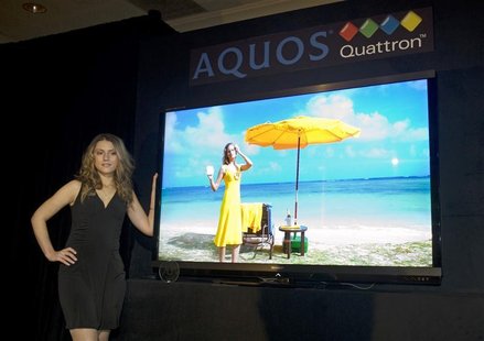 A model stands by a Sharp Quattron 70-inch LCD TV during a news conference at the 2011 International CES in Las Vegas A model stands by a Sharp Quattron 70-inch LCD TV during a news conference at the 2011 International CES in Las Vegas