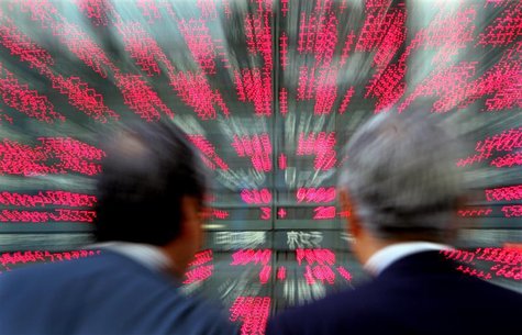 Japanese businessmen look closely at stock prices in Tokyo Japanese businessmen look closely at stock prices in Tokyo