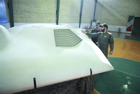 Undated picture shows member of Iran's revolutionary guard pointing at U.S. RQ-170 unmanned spy plane as he speaks with Hajizadeh at unknown Undated picture shows member of Iran's revolutionary guard pointing at U.S. RQ-170 unmanned spy plane as he speaks with Hajizadeh at unknown