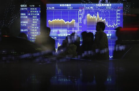 Passersby walk in front of an electric board displaying movements of the Japanese yen's exchange rate against the U.S. dollar outside a brok Passersby walk in front of an electric board displaying movements of the Japanese yen's exchange rate against the U.S. dollar outside a brok