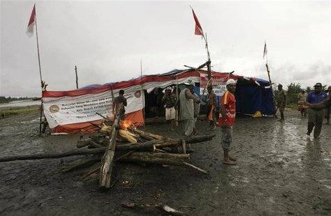 Tribesmen carry bows and arrows as they block a road in Timika Tribesmen carry bows and arrows as they block a road in Timika