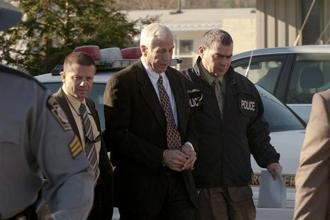 Former Penn State University football defensive coordinator Sandusky is led away by police after being arrested in a sex crimes investigatio Former Penn State University football defensive coordinator Sandusky is led away by police after being arrested in a sex crimes investigatio