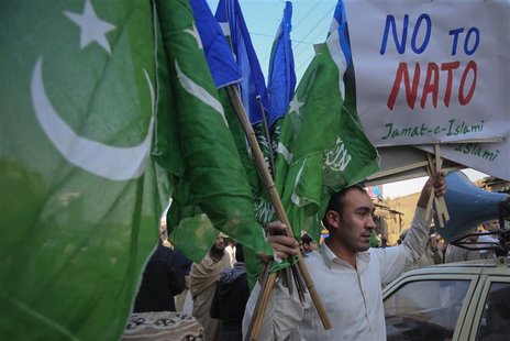 A supporter of Jamaat-e-Islami (JI), a religious and political party, holds collected party flags and placards after an anti-American demons A supporter of Jamaat-e-Islami (JI), a religious and political party, holds collected party flags and placards after an anti-American demons