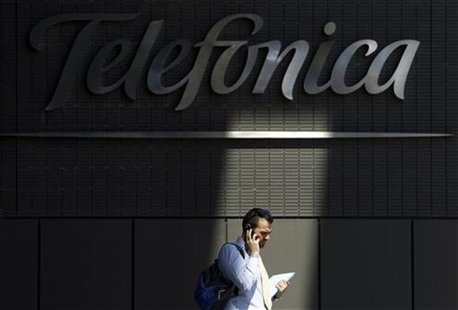 A man talks on his cell phone outside Telefonica headquarters in Madrid A man talks on his cell phone outside Telefonica headquarters in Madrid